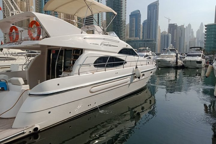 Experience the luxurious embrace of a private yacht gliding through Dubai's iconic skyline while enjoying refreshing drinks and stunning views of famous landmarks along the Persian Gulf.